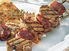 spiedini di filetto di maiale con albicocche secche avvolte in pancetta e pane alle erbe