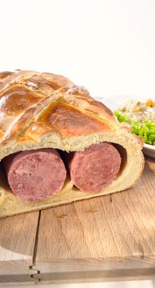 Zungenwurst alla bernese in pane di treccia con insalata di cipolle e uvetta